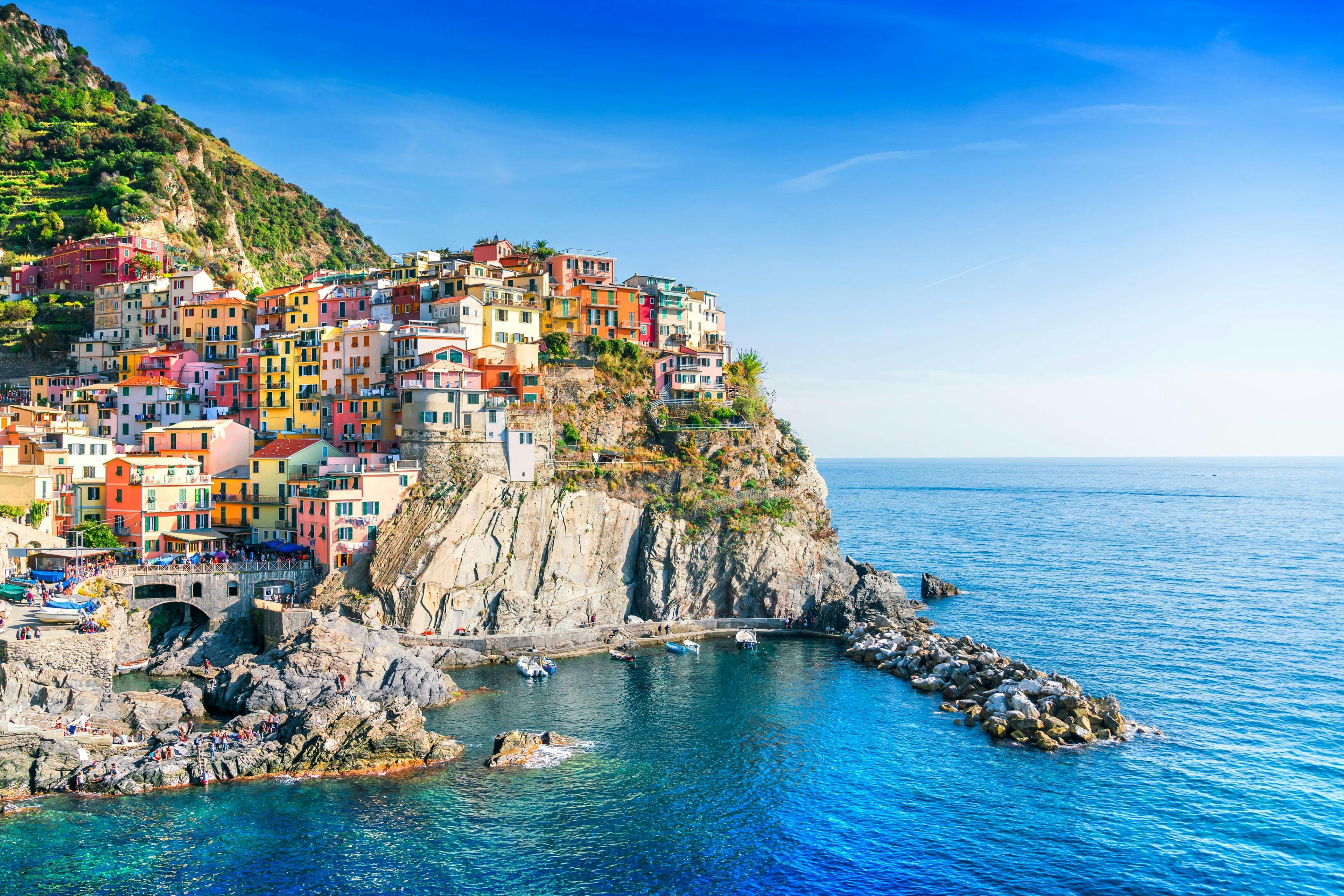 An image of the picturesque little village of Manarola perched on top of the cliffs, one of the sights afforded to those who go on a boat trip along the Cinque Terre coast.