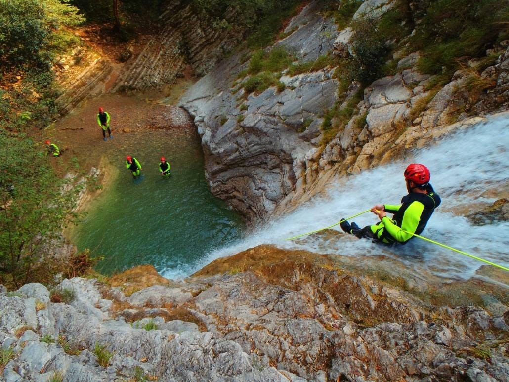 Canyoning in Torrente Vione in Tignale at Lake Garda - Cover A participant is sliding in the canyon during one of the Canyoning in Torrente Vione at Lake Garda.