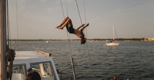 Private Bootstour von Alghero bei Sonnenuntergang mit Apértitif mit Escursioni in Barca Alghero Eine Person springt ins Wasser bei der Privaten Bootstour von Alghero bei Sonnenuntergang mit Apértitif mit Escursioni in Barca Alghero.