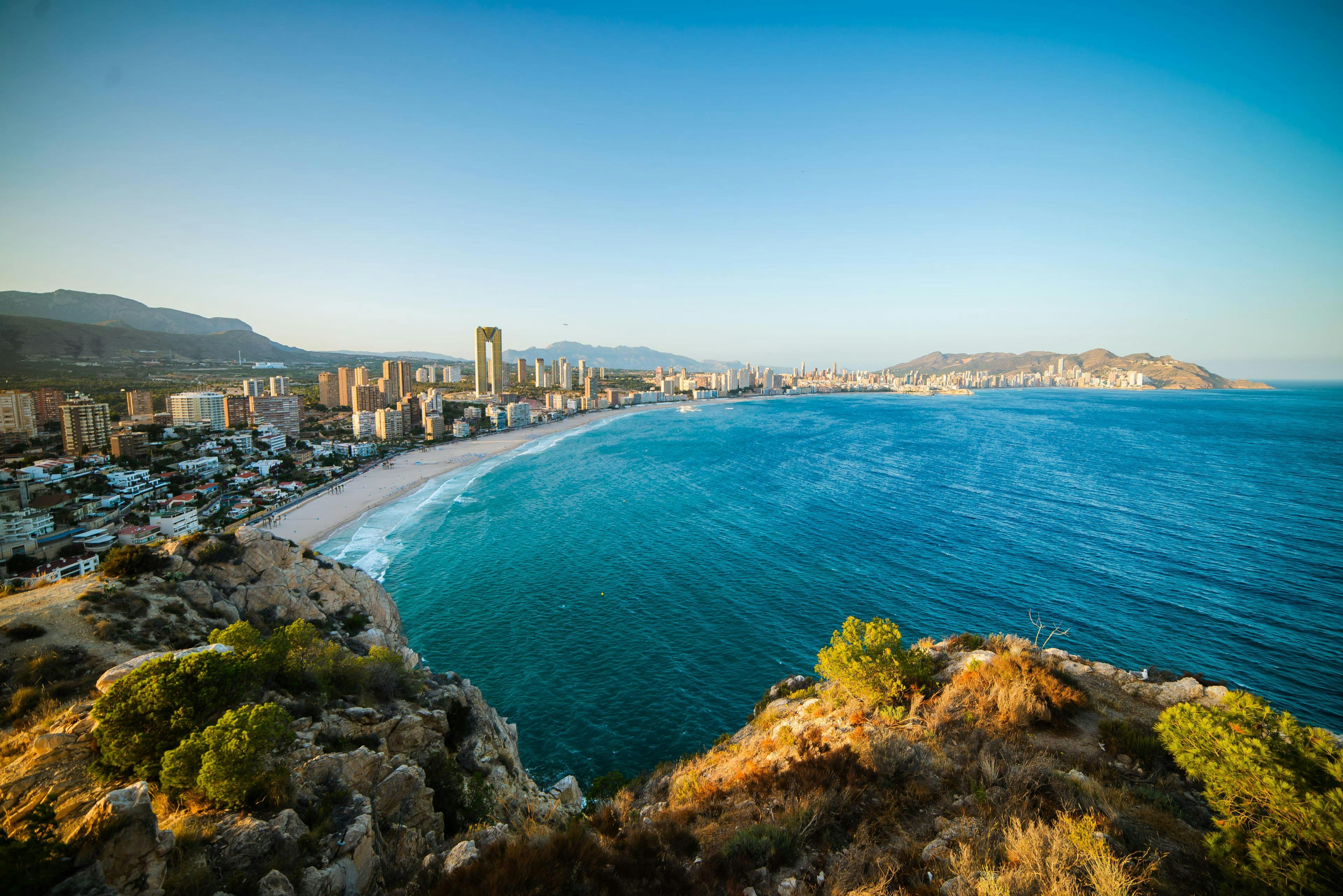 Una imagen de la playa de arena donde uno se puede subir a una moto acuática y hacer otras actividades de deportes acuáticos en Benidorm.