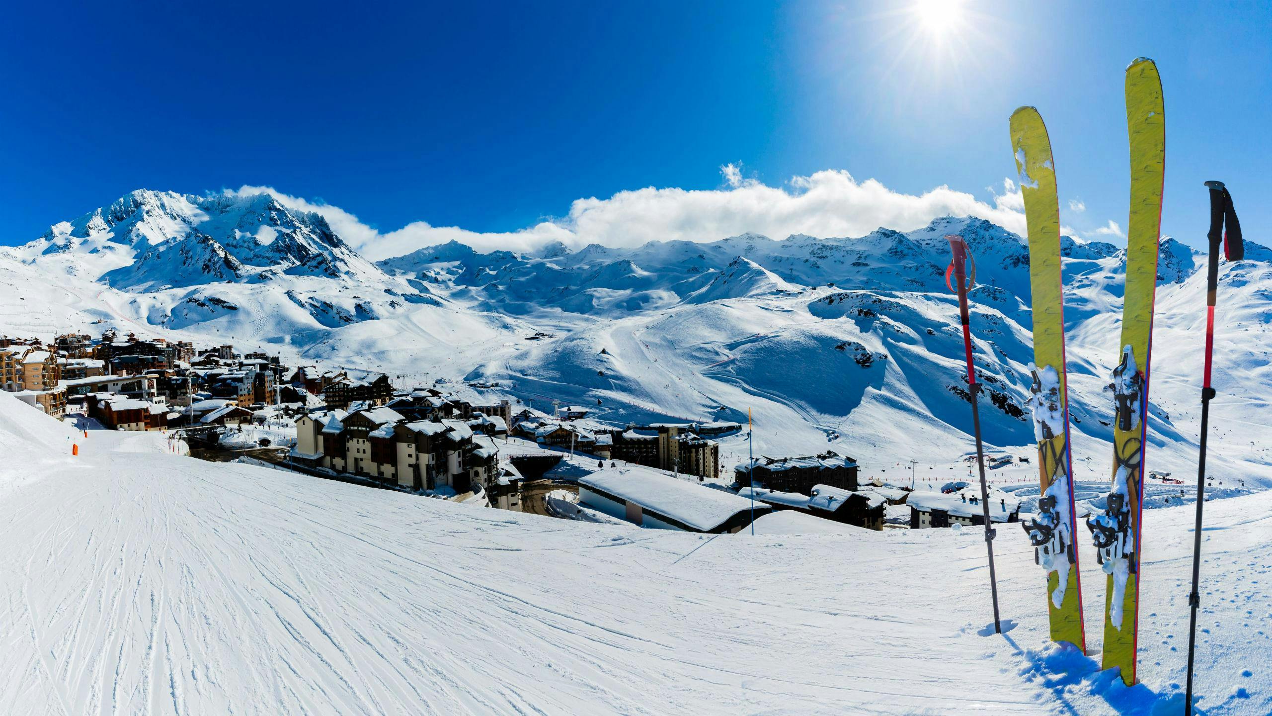 Une paire de skis plantée dans la neige sur l'une des pistes de Val Thorens, une station de ski française où les écoles de ski locales proposent différents cours de ski à ceux qui souhaitent apprendre à skier.